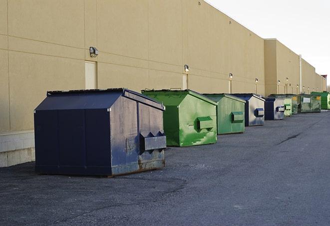 a fleet of red and blue construction dumpsters available for use in Alton, TX